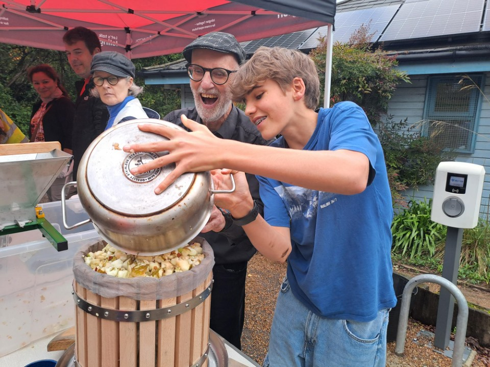 Tom adding apples to a press at a Gillespie Park event